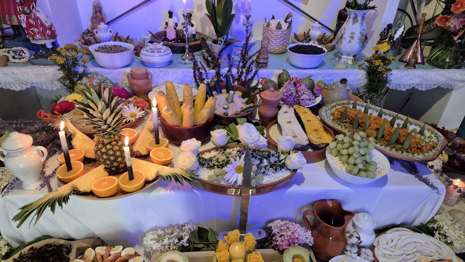 Grande table avec les fruits, les fleurs et les préparations de la Comida de Santo